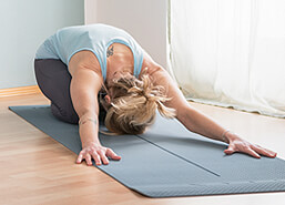 Monika Schindlbeck bei einer Yoga-Übung auf der Matte (Blatt)